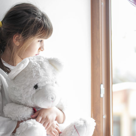 Little cute girl boring at home with her teddy bear